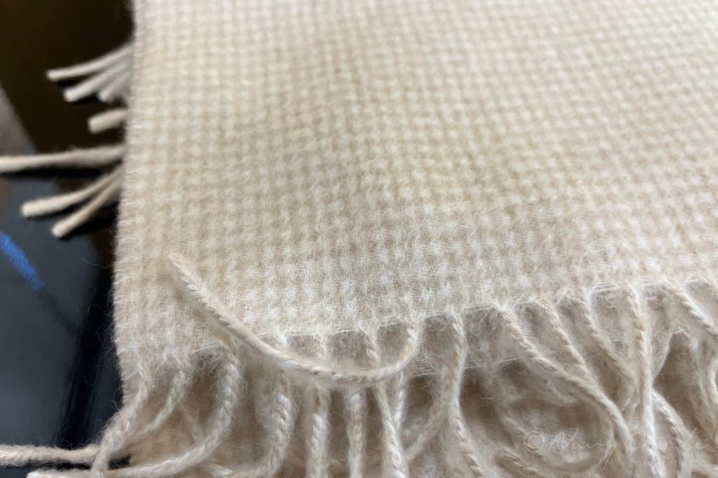 マフラーに近づいたところ。交織によって模様が生まれていることがわかる A closer look at a scarf, highlighting the pattern brought by the contrast of the two different cashmeres